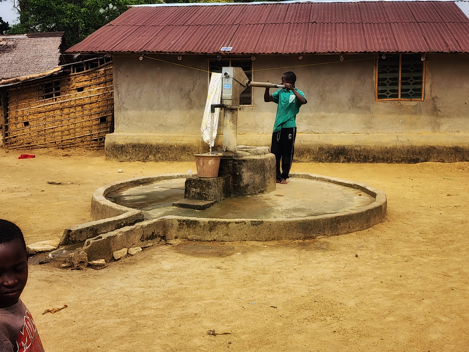 Boy drawing clean water from the Malema Town well in Liberia